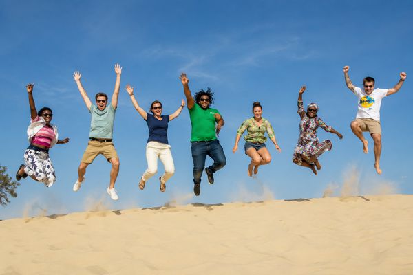 Étudiants sautant sur une dune de sable au Sénégal